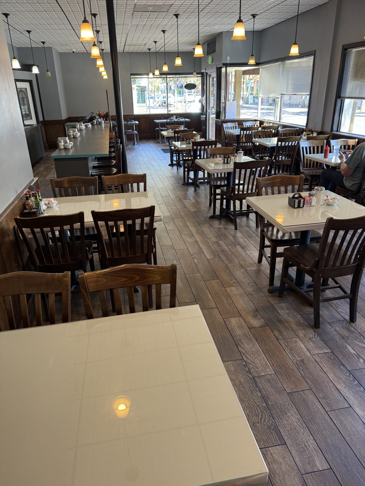 The dining room at M&M with pendant lights and windows onto Main Street