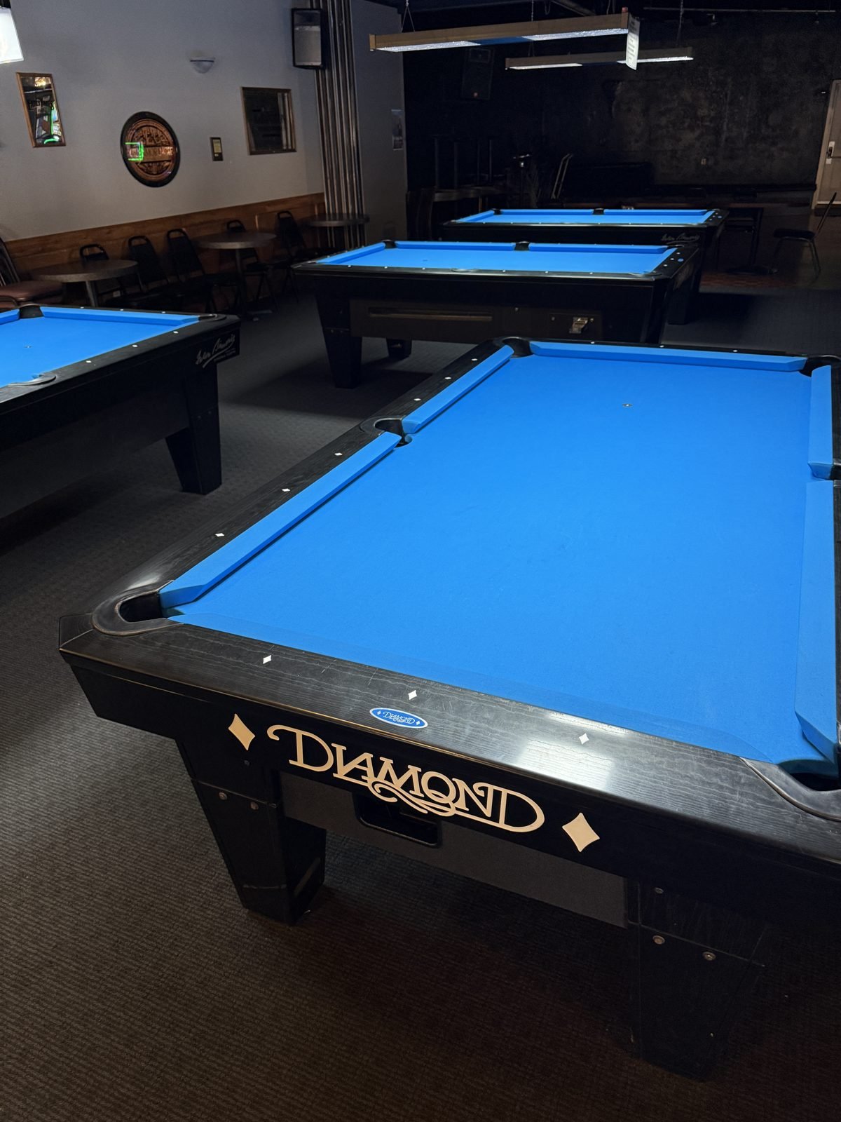 Diamond pool tables with blue felt in the pool room at M&M